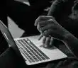 grayscale photo of person using MacBook