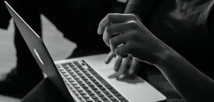 grayscale photo of person using MacBook